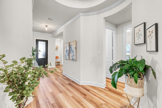 foyer entrance with light hardwood / wood-style flooring and ornamental molding