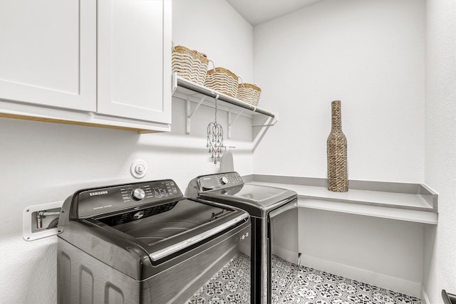 clothes washing area with light tile patterned flooring, cabinets, and independent washer and dryer