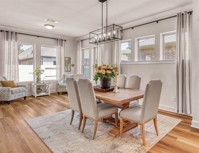 dining space with a chandelier, light hardwood / wood-style floors, and plenty of natural light