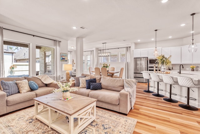 living room with light wood-type flooring and sink