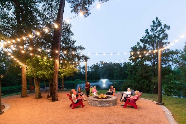 view of property's community with a water view and a fire pit