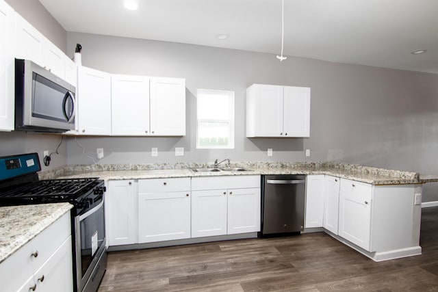 1709 Stevens St, Houston, TX 77026 - kitchen featuring stainless steel appliances, a peninsula, white cabinets, and recessed lighting