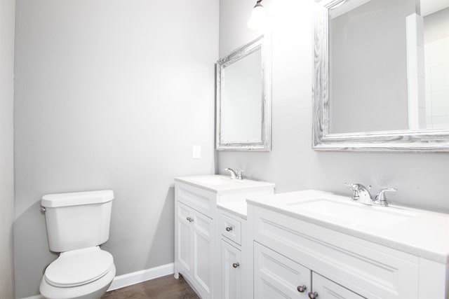 bathroom with hardwood / wood-style floors, vanity, and toilet