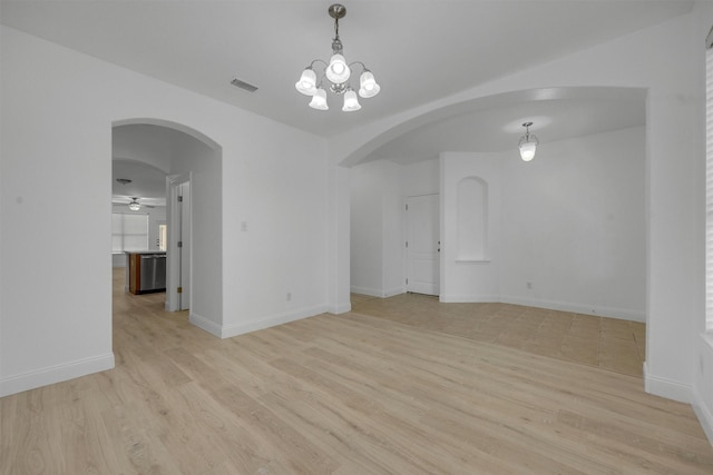 spare room featuring light hardwood / wood-style flooring and ceiling fan with notable chandelier