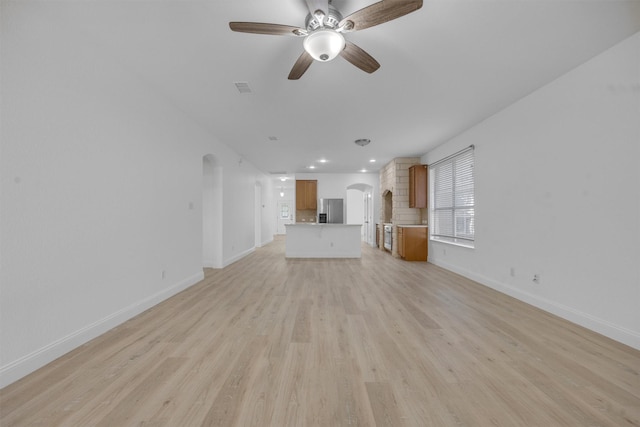 unfurnished living room with ceiling fan and light wood-type flooring