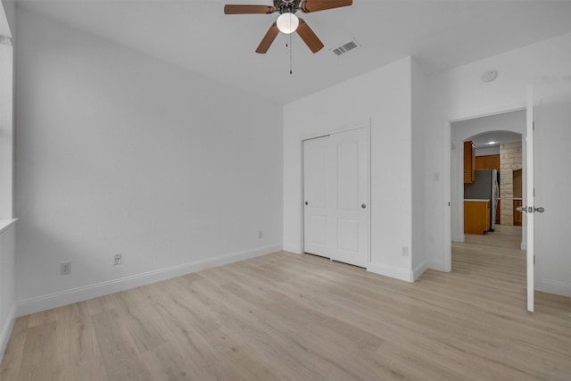 unfurnished bedroom featuring stainless steel fridge, ceiling fan, and light hardwood / wood-style floors