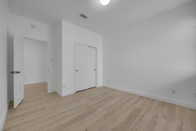 unfurnished bedroom featuring a closet and light wood-type flooring