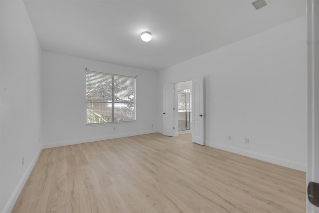 empty room with light hardwood / wood-style flooring