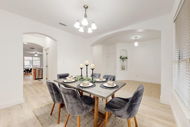 dining space featuring a notable chandelier and light wood-type flooring