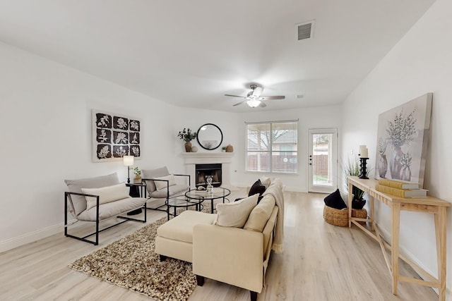 living room with ceiling fan and light hardwood / wood-style flooring