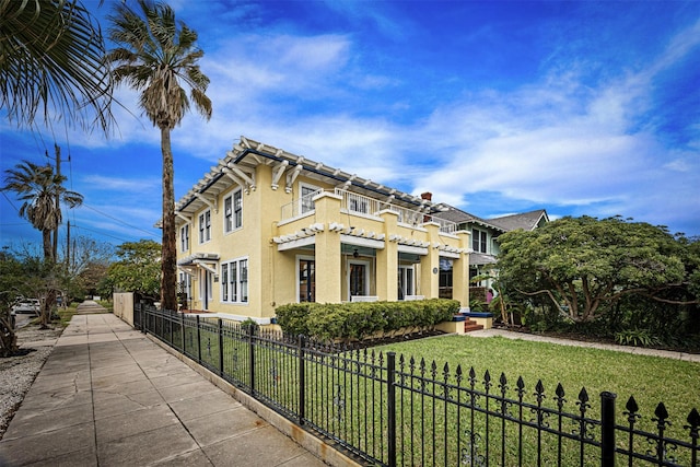 view of side of home with a balcony and a lawn