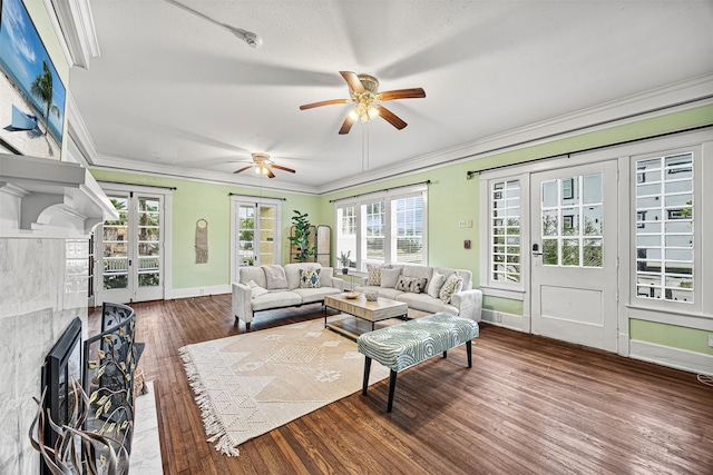 living room featuring crown molding, a fireplace, ceiling fan, and dark hardwood / wood-style floors