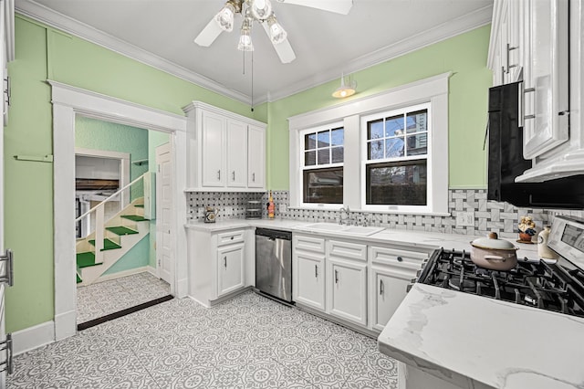 kitchen with ornamental molding, stainless steel appliances, ceiling fan, sink, and white cabinets