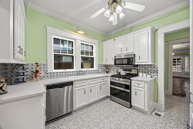 kitchen featuring ceiling fan, sink, stainless steel appliances, tasteful backsplash, and white cabinets