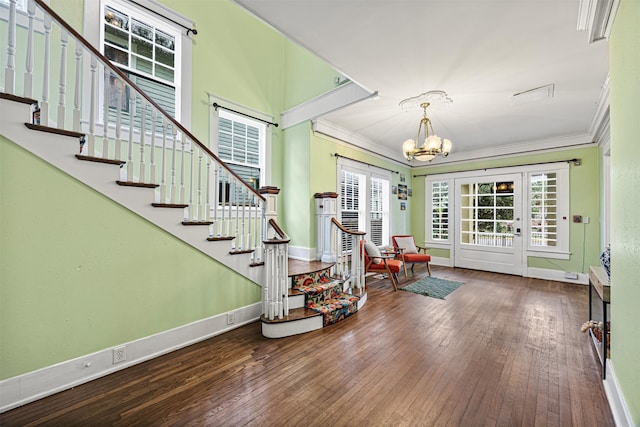 foyer with wood-type flooring, crown molding, and an inviting chandelier