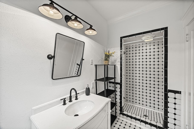 bathroom featuring vanity, a tile shower, and crown molding