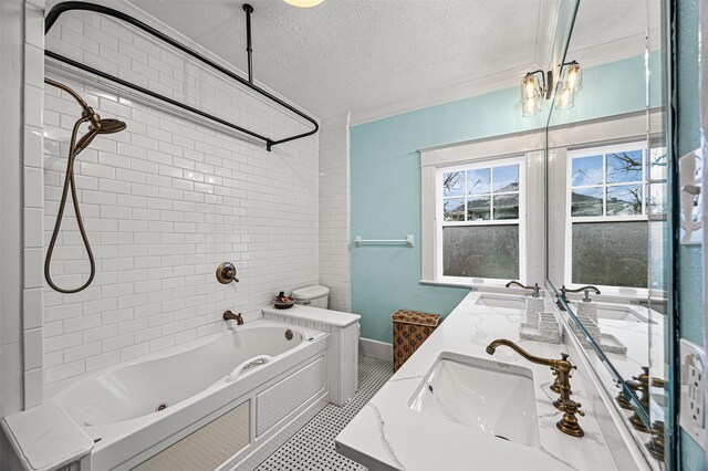 full bathroom with a textured ceiling, vanity, crown molding, toilet, and tiled shower / bath