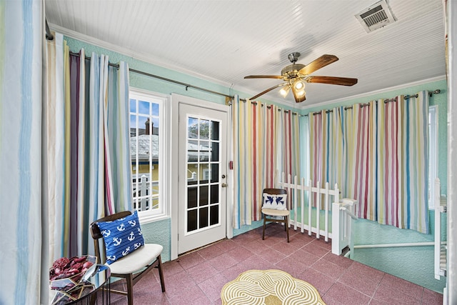 unfurnished sunroom featuring ceiling fan