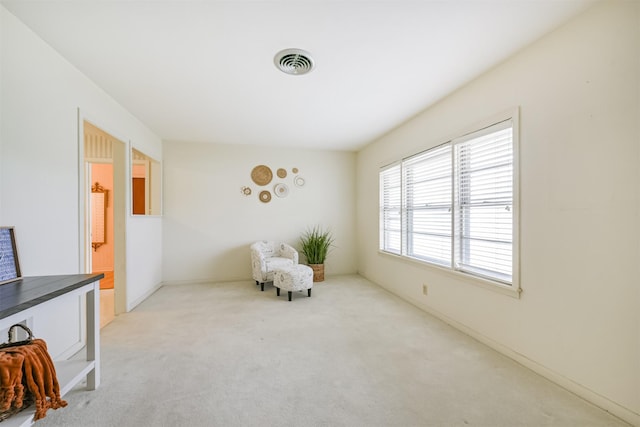 living area featuring light carpet