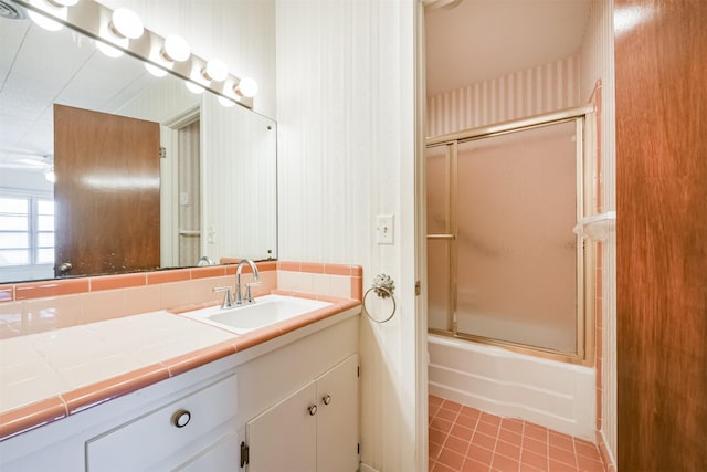 bathroom with tile patterned floors, vanity, and combined bath / shower with glass door