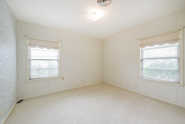 unfurnished room featuring light carpet and a healthy amount of sunlight