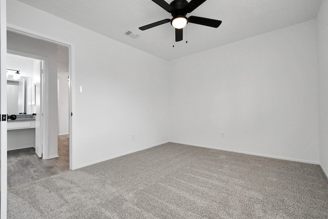 carpeted spare room featuring ceiling fan