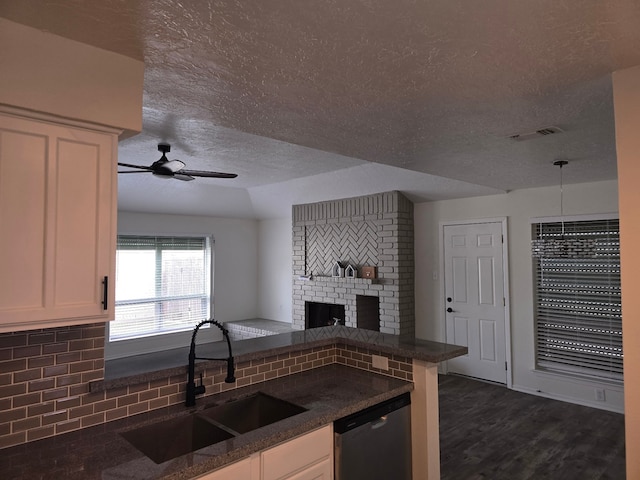 kitchen featuring backsplash, sink, stainless steel dishwasher, dark hardwood / wood-style floors, and kitchen peninsula