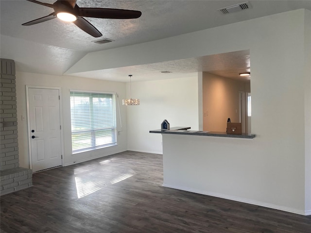 unfurnished living room featuring a textured ceiling, dark hardwood / wood-style flooring, vaulted ceiling, and ceiling fan