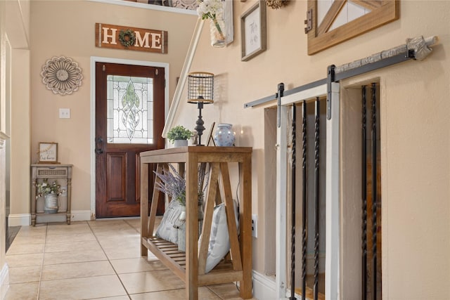 foyer featuring a barn door and light tile patterned floors