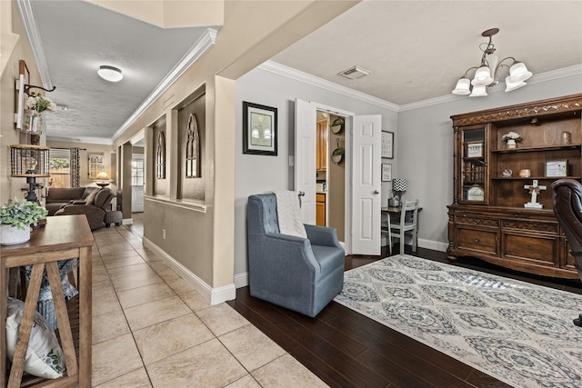 hallway featuring a chandelier, light hardwood / wood-style floors, and crown molding