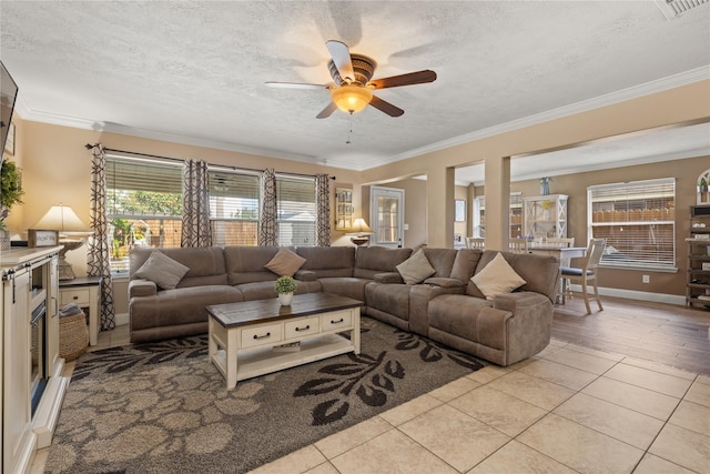 living room featuring crown molding, light tile patterned flooring, a textured ceiling, and ceiling fan