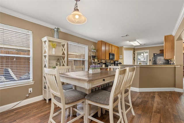 dining room with dark hardwood / wood-style flooring and crown molding