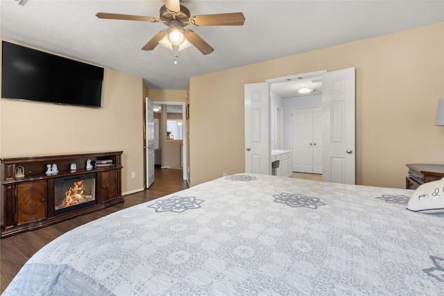 bedroom with dark hardwood / wood-style flooring, ensuite bath, and ceiling fan