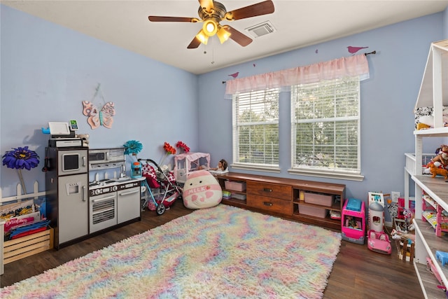 playroom with ceiling fan and dark wood-type flooring