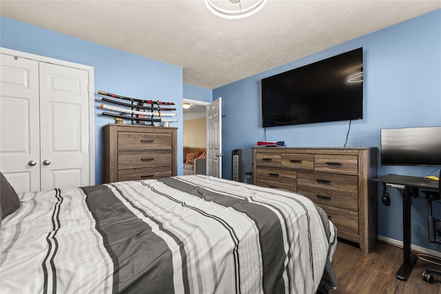 bedroom with a textured ceiling, a closet, and dark hardwood / wood-style floors