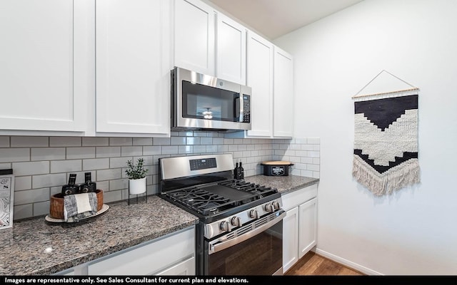 kitchen featuring dark stone countertops, white cabinetry, and stainless steel appliances