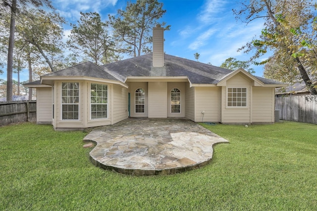 rear view of property featuring a patio and a lawn