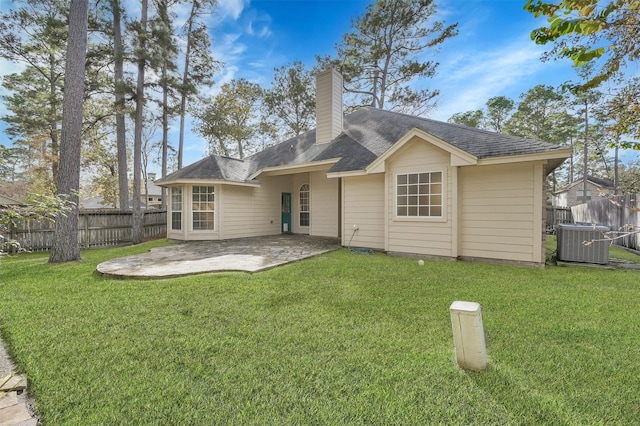 rear view of property featuring a lawn, cooling unit, and a patio