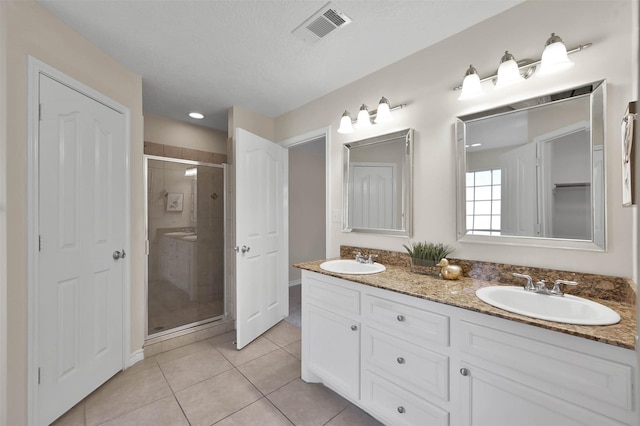 bathroom featuring a textured ceiling, vanity, tile patterned floors, and an enclosed shower