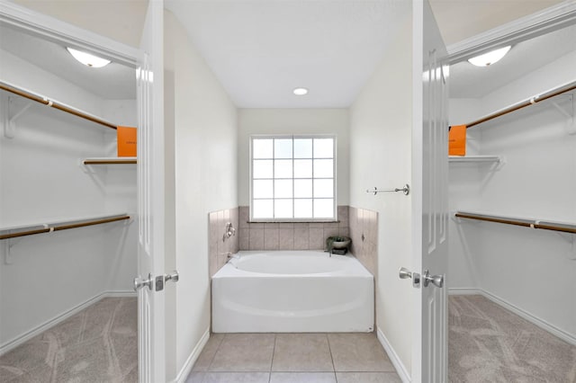 bathroom with tile patterned flooring and a tub to relax in