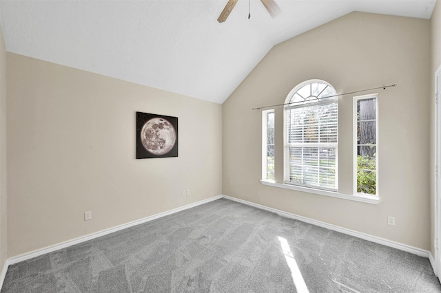 empty room with ceiling fan, carpet floors, and vaulted ceiling