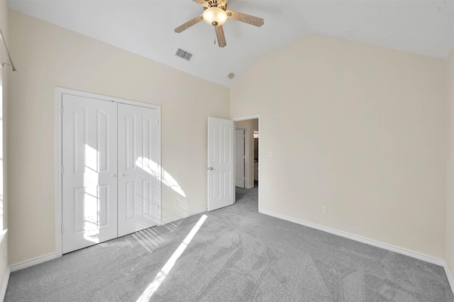 unfurnished bedroom featuring carpet floors, a closet, ceiling fan, and lofted ceiling