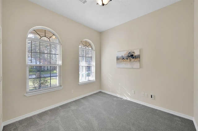 carpeted spare room with baseboards