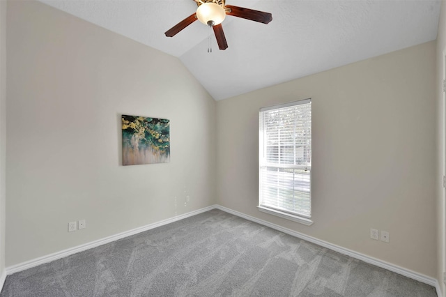 empty room featuring carpet flooring, baseboards, lofted ceiling, and a ceiling fan