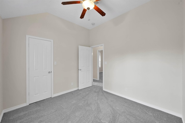 unfurnished room with vaulted ceiling, carpet, baseboards, and ceiling fan