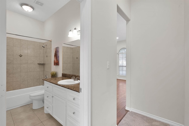 bathroom featuring tile patterned flooring, visible vents, toilet, shower / bath combination, and vanity