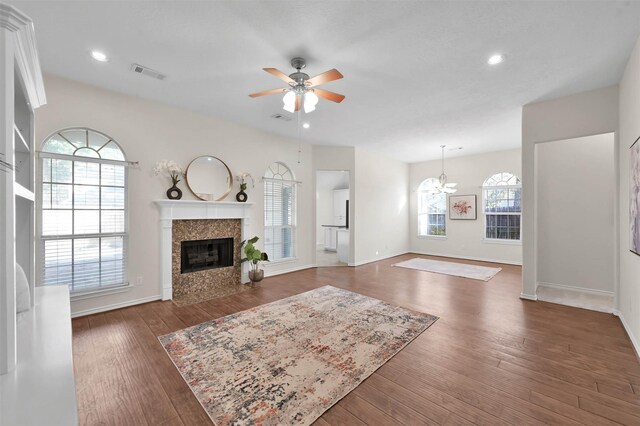 living room featuring ceiling fan with notable chandelier and dark hardwood / wood-style floors