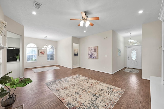 entryway featuring a textured ceiling, ceiling fan with notable chandelier, and dark hardwood / wood-style floors