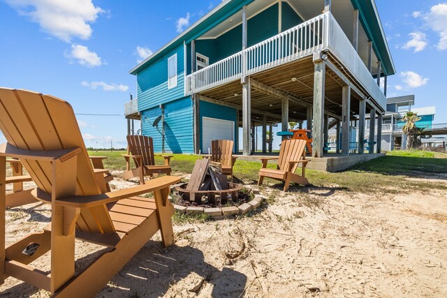 rear view of house with a fire pit and a deck