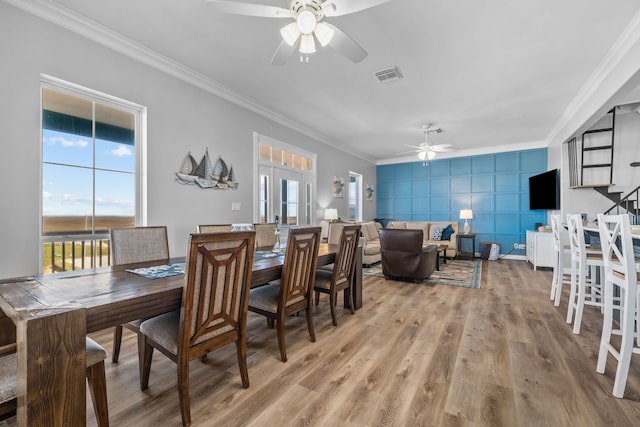 dining space featuring light hardwood / wood-style flooring, tile walls, ornamental molding, and ceiling fan